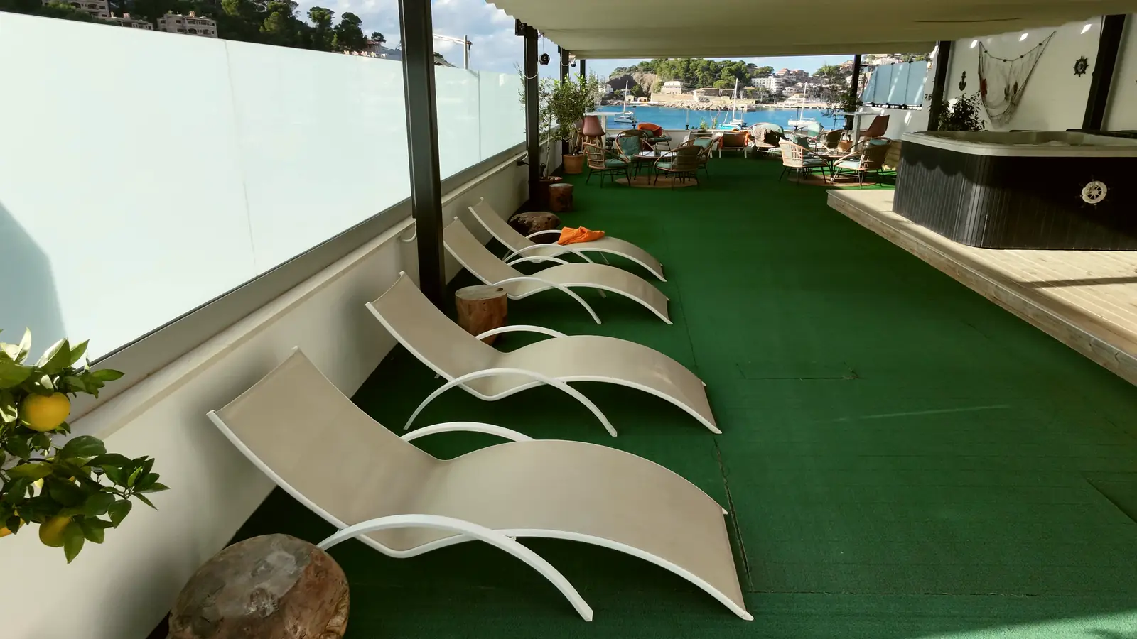 Terraza con tumbonas y el puerto al fondo