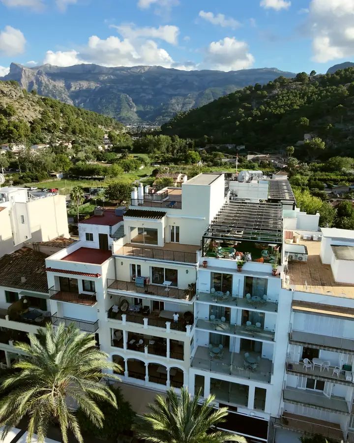 Fachada de hotel frente al mar con la sierra detrás