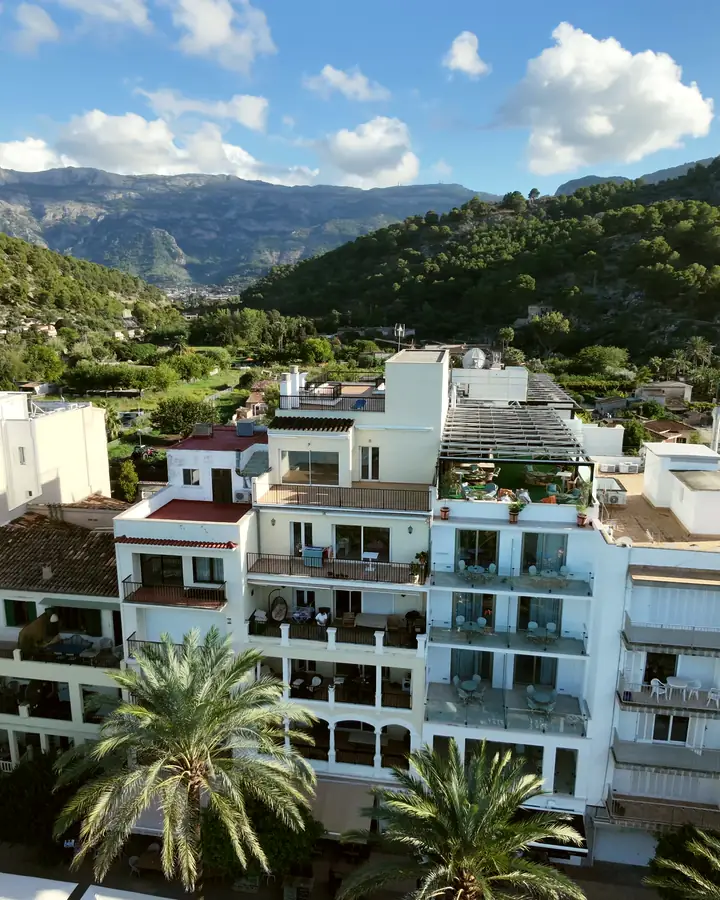 Edificio de apartamentos con terrazas y palmeras delante