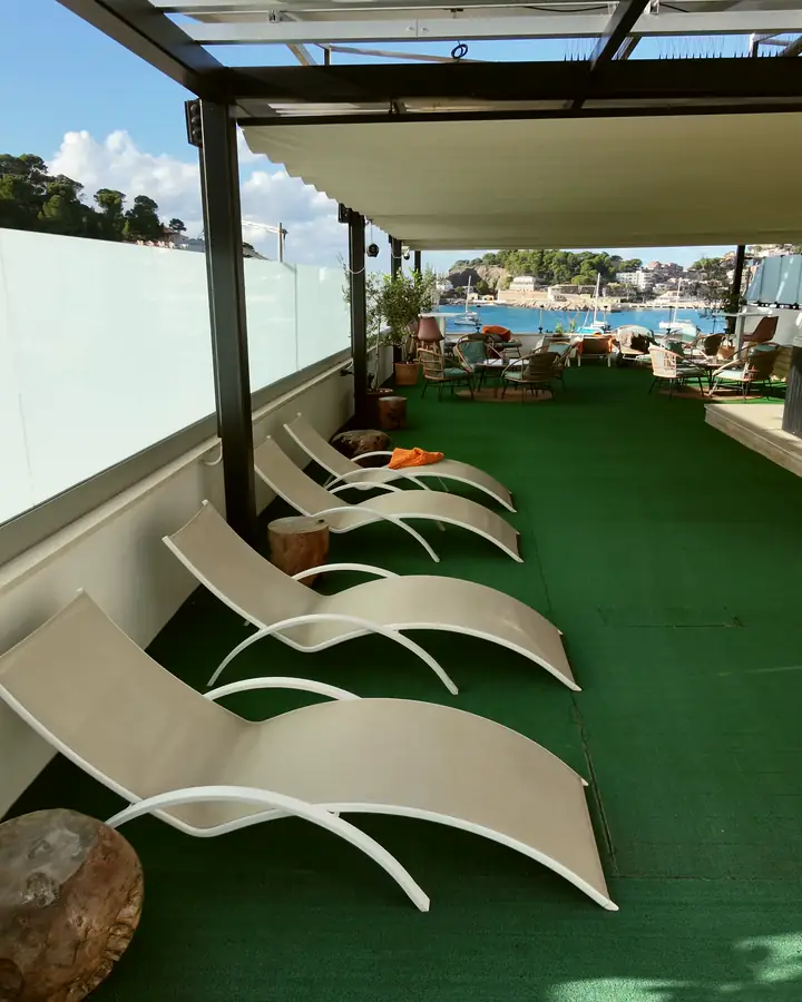 Terraza en la azotea con tumbonas y vistas al puerto